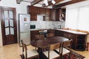 a kitchen with a wooden table and a refrigerator at Садиба Гармонія in Guta