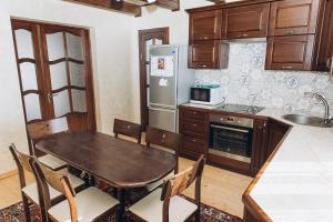 a kitchen with a wooden table and a refrigerator at Садиба Гармонія in Guta