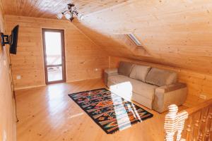 a living room with a couch in a log cabin at Садиба Гармонія in Guta