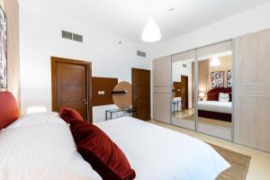 a bedroom with a large white bed and a mirror at FAM Living - Al Safa Residences - SZR in Dubai