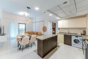 a kitchen and dining room with a table and chairs at FAM Living - Al Safa Residences - SZR in Dubai