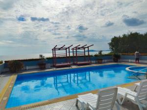 a large swimming pool with white chairs at AvataraA B32 by malai in Ban Tha Fat