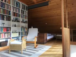Habitación con biblioteca con silla y estanterías en The end of the road-entire house near Bled, en Radovljica