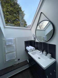 a bathroom with a sink and a mirror and a window at Love Viou in Ramonchamp