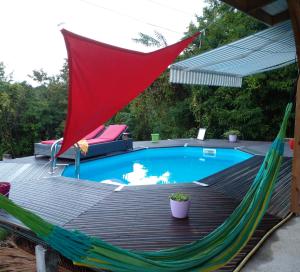 a hammock on a deck next to a pool at Chambre chez l'habitant avec piscine privative et vue panoramique sur la mer des caraïbes in Desmarinières