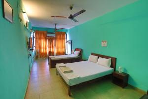 um quarto com uma cama e um sofá num quarto em Hotel Orfil em Calangute