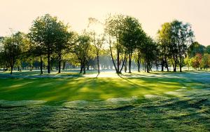 a golf course with trees and a putting green at The Lodge at Kingswood in Epsom