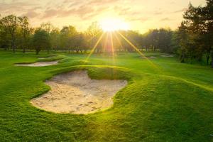 an aerial view of a golf course with the sun setting at The Lodge at Kingswood in Epsom