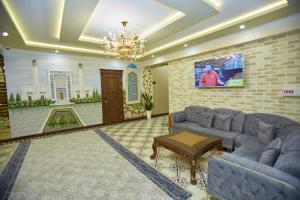 uma sala de estar com sofás e um lustre em HOTEL SHAHDIL em Samarkand
