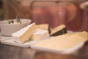 un piatto di formaggio su un tavolo con una ciotola di cibo di Emma Historic Hotel a Villabassa