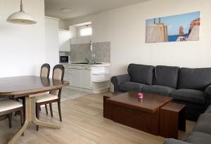 uma sala de estar com um sofá e uma mesa em Haus Atlantic Whg. 601 em Cuxhaven