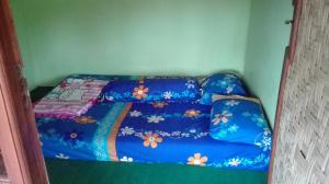 a blue couch in a corner of a room at Ijen Miner Family Homestay in Banyuwangi