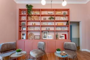 Esta habitación está dividida en color rosa y cuenta con 2 sillas y una mesa. en Terra Artis Guest House, en Florencia