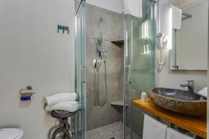 La salle de bains est pourvue d'un lavabo et d'une douche en verre. dans l'établissement Casa Gardenia -affittacamere, à Gatteo