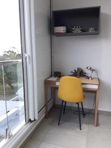 a desk with a yellow chair next to a window at Maison TONGA piscine /jacuzzi chambre de luxe in Saint-Pierre