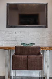 a table with a chair and a television on a wall at Casa Gardenia -affittacamere in Gatteo