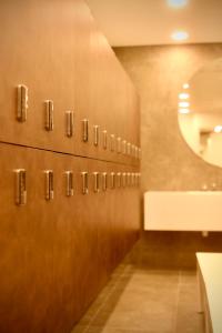 La salle de bains est pourvue d'une rangée de portes en bois et d'un miroir. dans l'établissement The Icon Limassol, à Limassol