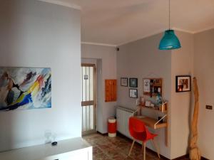 a living room with a red chair and a desk at Casa Vacanza Giardino in Guardiabruna