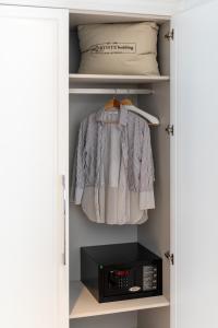 a closet with a microwave and a shirt in it at Motif Hotel Çeşme in Cesme