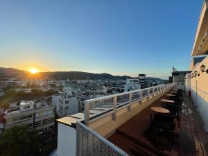 a balcony with tables and chairs on a building with the sunset at Hotel Aru Kyoto Sanjo Kiyamachi Do-ri in Kyoto