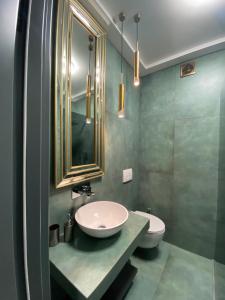 La salle de bains est pourvue d'un lavabo, de toilettes et d'un miroir. dans l'établissement Apartments Lux in city center Lviv, à Lviv