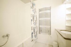 a white bathroom with a shower and a sink at HeyMi Apartments Karlsplatz in Vienna