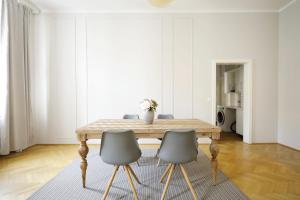 a dining room with a wooden table and two chairs at HeyMi Apartments Karlsplatz in Vienna +22 photos