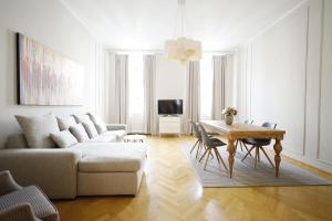 uma sala de estar com um sofá e uma mesa em HeyMi Apartments Karlsplatz em Viena