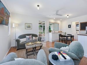 a living room with a couch and chairs and a table at Sweet Cottage, sleeps 4 - stroll to Maleny in Maleny
