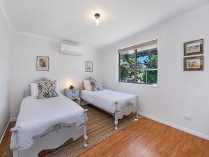a bedroom with two beds and a window at Sweet Cottage, sleeps 4 - stroll to Maleny in Maleny