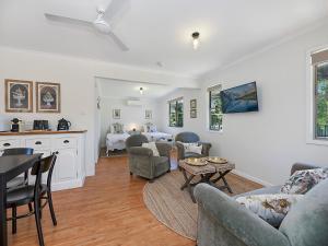 a living room with a couch and chairs and a table at Sweet Cottage, sleeps 4 - stroll to Maleny in Maleny