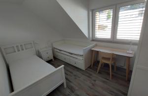 a bedroom with two beds and a desk and a table at Apartmán08 in Dolní Morava