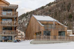 ein Holzgebäude im Schnee mit einem Berg in der Unterkunft Montela Hotel & Resort - Montela Pavillon in Saas-Grund