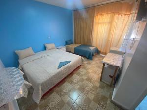 a blue bedroom with a bed and a chair at City Center Hostel in Aqaba