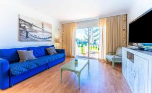 sala de estar con sofá azul y TV en Apartamento Lázaro 26 Terraza con Vistas al Mar en Santa Úrsula
