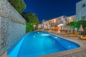 a swimming pool in front of a building at night at Panorama in Laganas