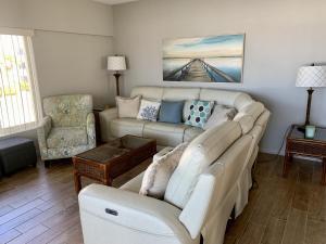 a living room with a white couch and chairs at Island House Beach Resort 4S in Point O'Rocks