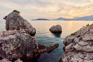 a group of rocks in a body of water at Blanche Cliff Apartments in Sveti Stefan