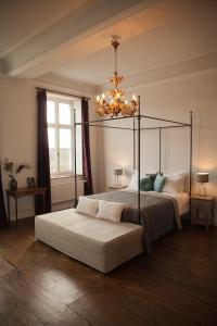 ein Schlafzimmer mit einem Himmelbett und einem Kronleuchter in der Unterkunft B&B De Kersentuin in Borgloon