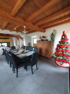 uma sala de jantar com uma mesa e uma árvore de Natal em Au chemin du paradis Gîte de 10 personnes 4 Etoiles em Saint-Martin-lez-Tatinghem