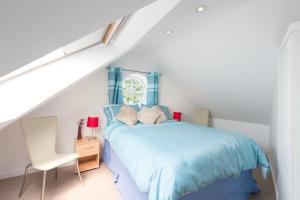 a bedroom with a blue bed and a window at Rosemorran Holiday Apartments in St Ives