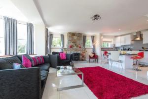 a living room with a couch and a red rug at Rosemorran Holiday Apartments in St Ives