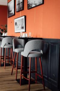 a bar with four stools in a restaurant at Dormy House in Étretat