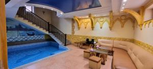 a living room with a pool and a couch and a staircase at Ureni Hotel in Kʼasakh