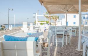 a restaurant with white tables and chairs and the ocean at Laza Beach in Skala
