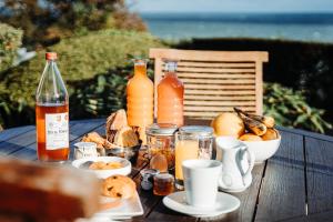 a table with bottles of juice and a bowl of food at Dormy House in Étretat