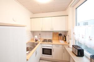 a kitchen with white cabinets and a sink at Studio Apartment - zentral mit Parkplatz - Balkon in Bayreuth