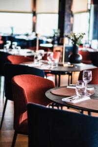 a restaurant with tables and chairs with wine glasses at Dormy House in Étretat