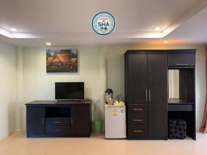 a room with a refrigerator and a cabinet and a clock at Naiyang Seaview Place Resort in Nai Yang Beach