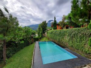 een zwembad in de tuin van een huis bij Saung Orange Village in Bogor